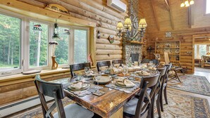 L’intérieur d’un chalet en bois, avec une table à manger dressée pour le repas, entourée de chaises.
