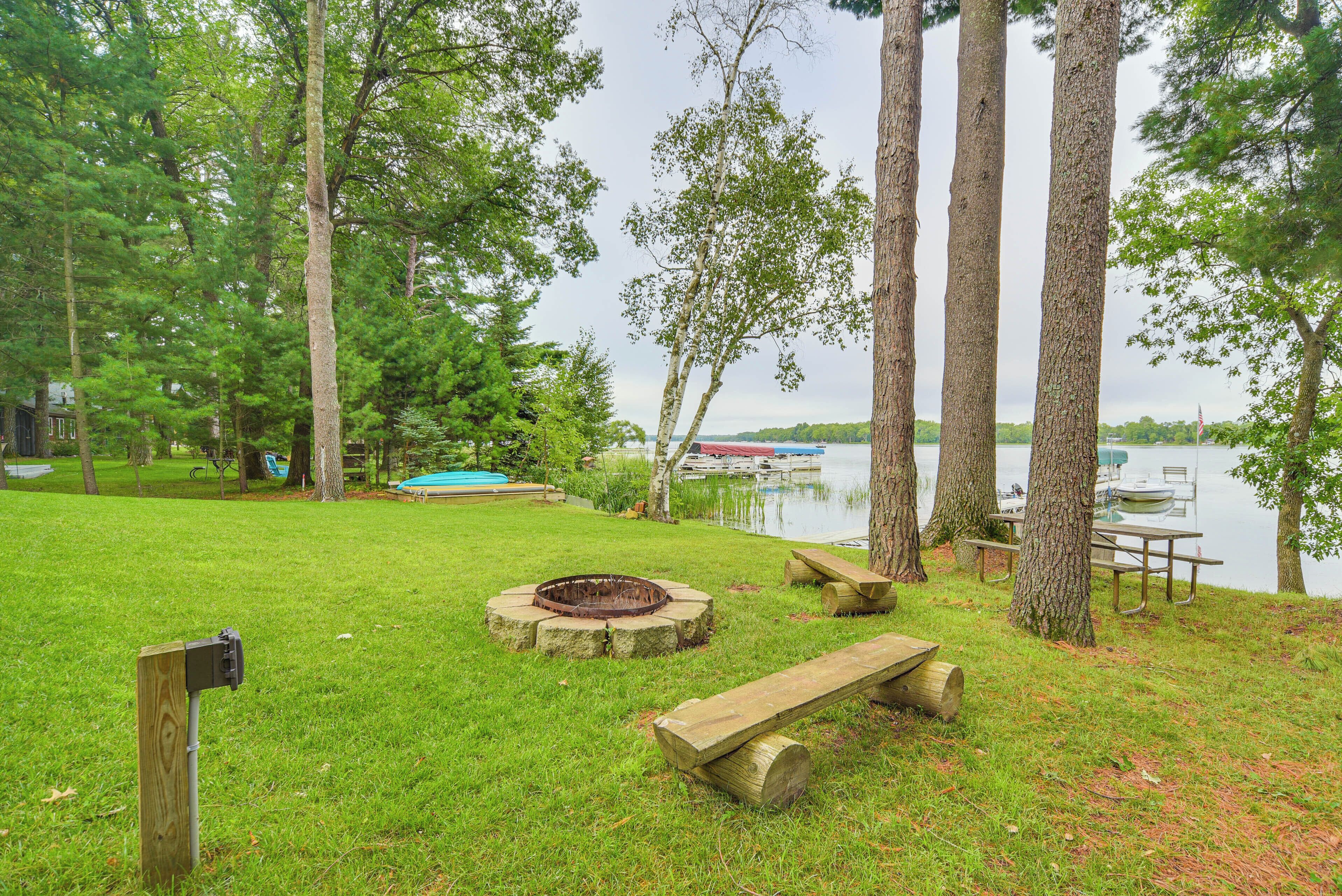 Un parc au bord du lac, équipé d’un foyer, de tables de pique-nique et d’un quai pour bateaux.