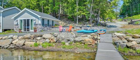 A lakeside cabin with a dock leading to a small boat.