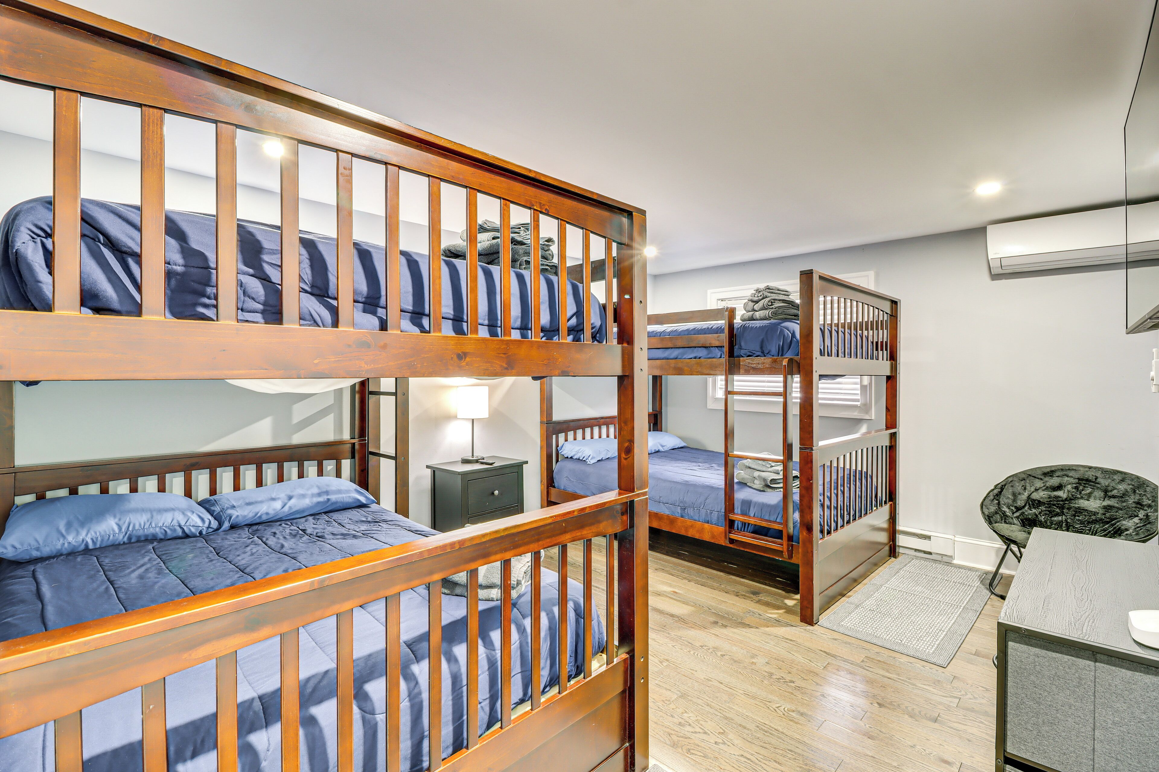 Une chambre de dortoir avec des lits superposés, un bureau et une chaise.