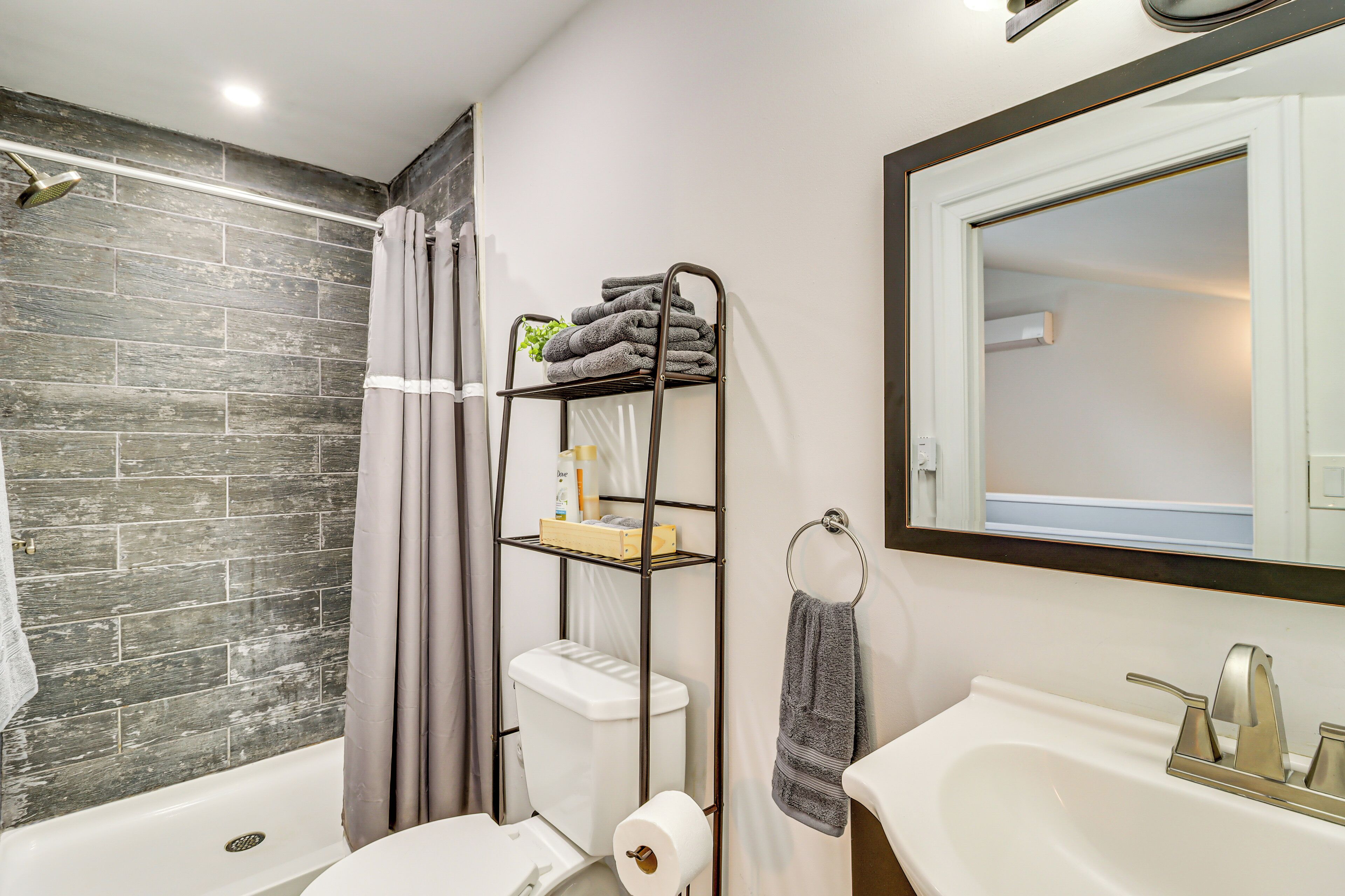 A bathroom with a shower, toilet, and sink.
