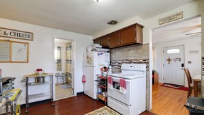A kitchen with wooden cabinets, a white stove, and a stainless steel cart. - Large Private Yard: Home 14 Mi to Niagara Falls! (Tonawanda)