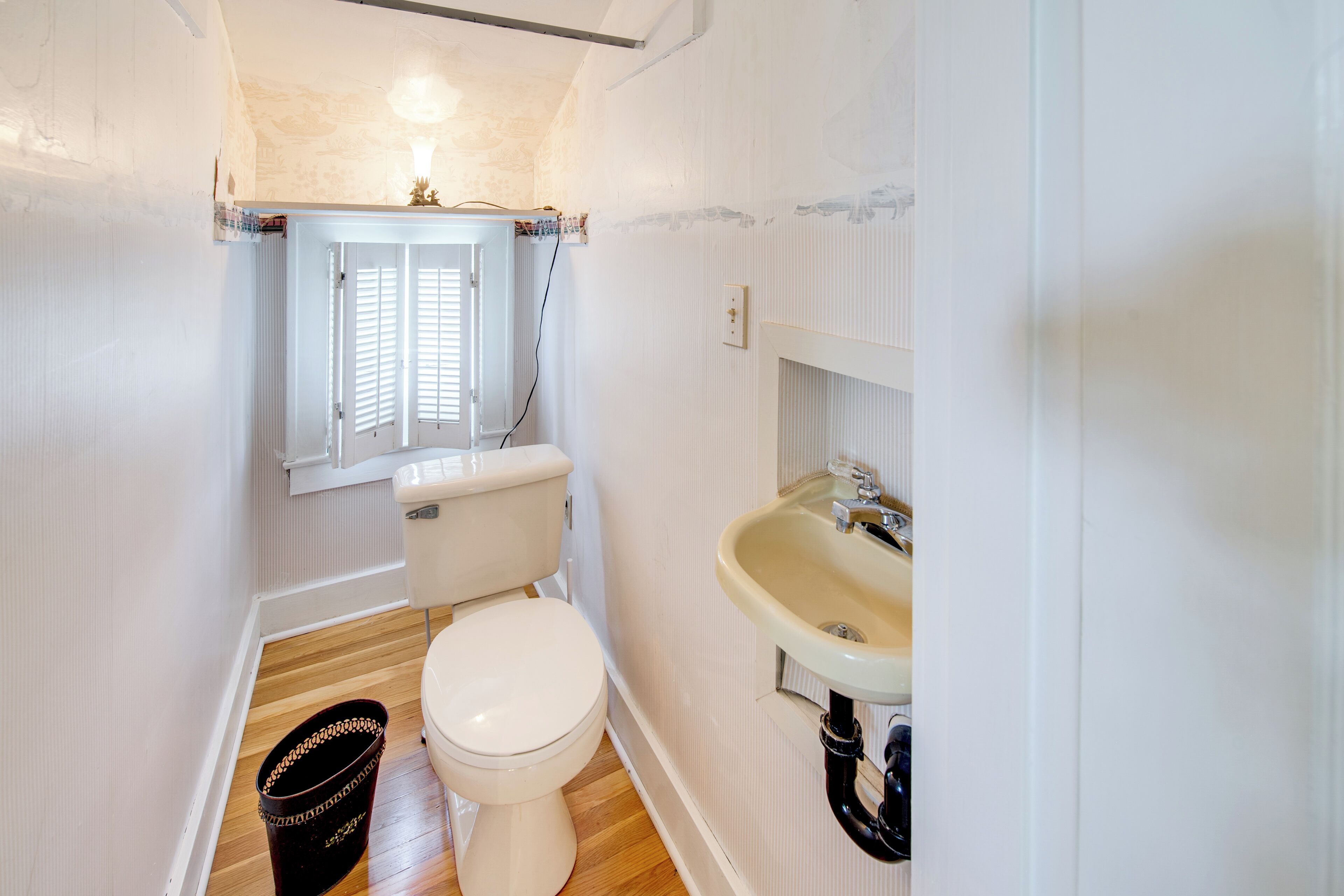 Un baño pequeño con inodoro, lavamanos y ventana.