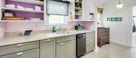 A kitchen with white cabinets, a sink, and a dishwasher.
