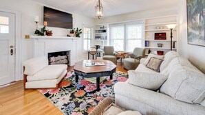 A living room with a fireplace, a coffee table, a sofa, and a bookshelf.