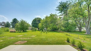 A spacious backyard with a concrete patio, various trees, and a well-maintained lawn. - Near Dtwn Harrisburg: Stylish Home w/ Patio & Yard (Camp Hill)