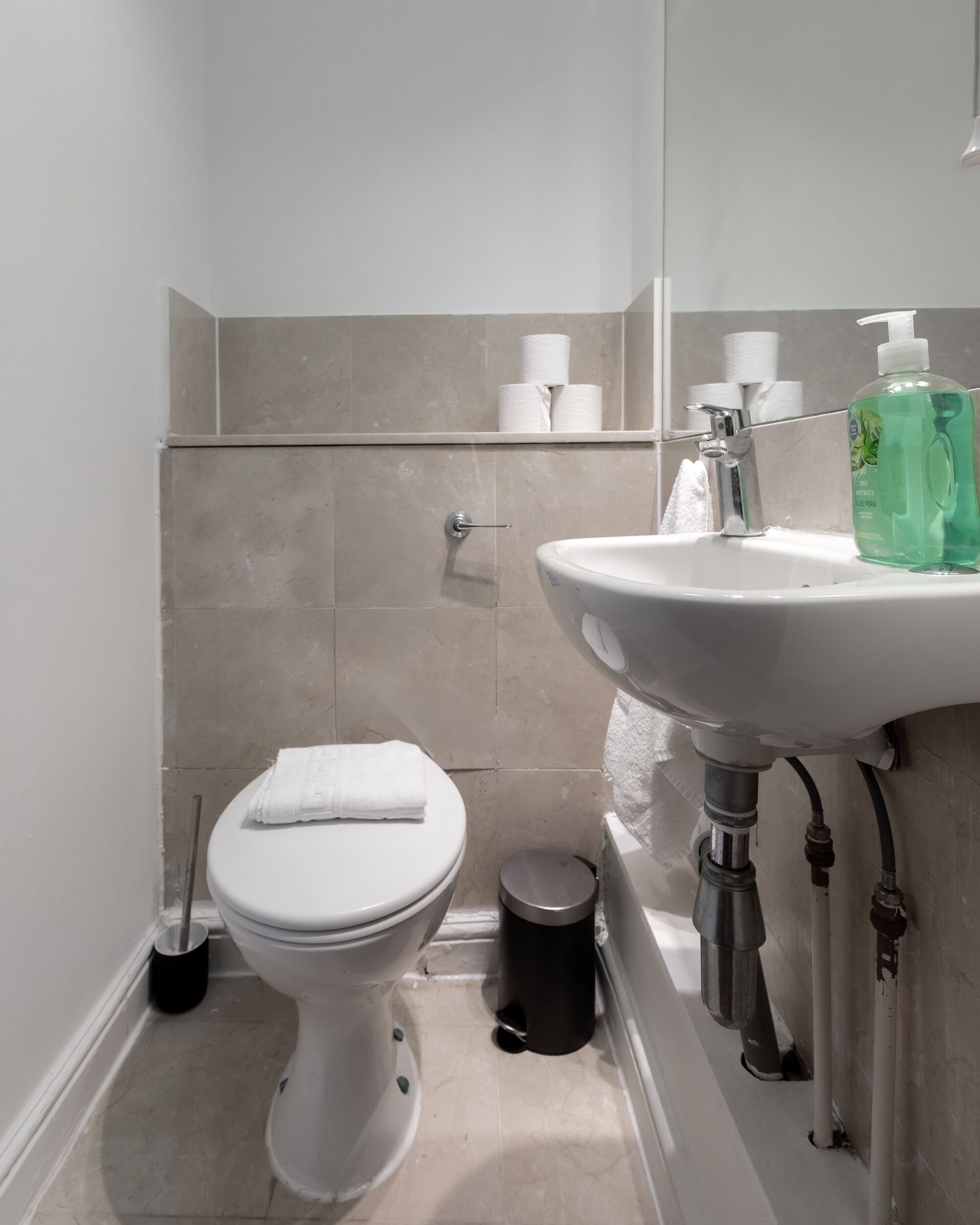 A modern bathroom with a toilet, sink, and mirror.