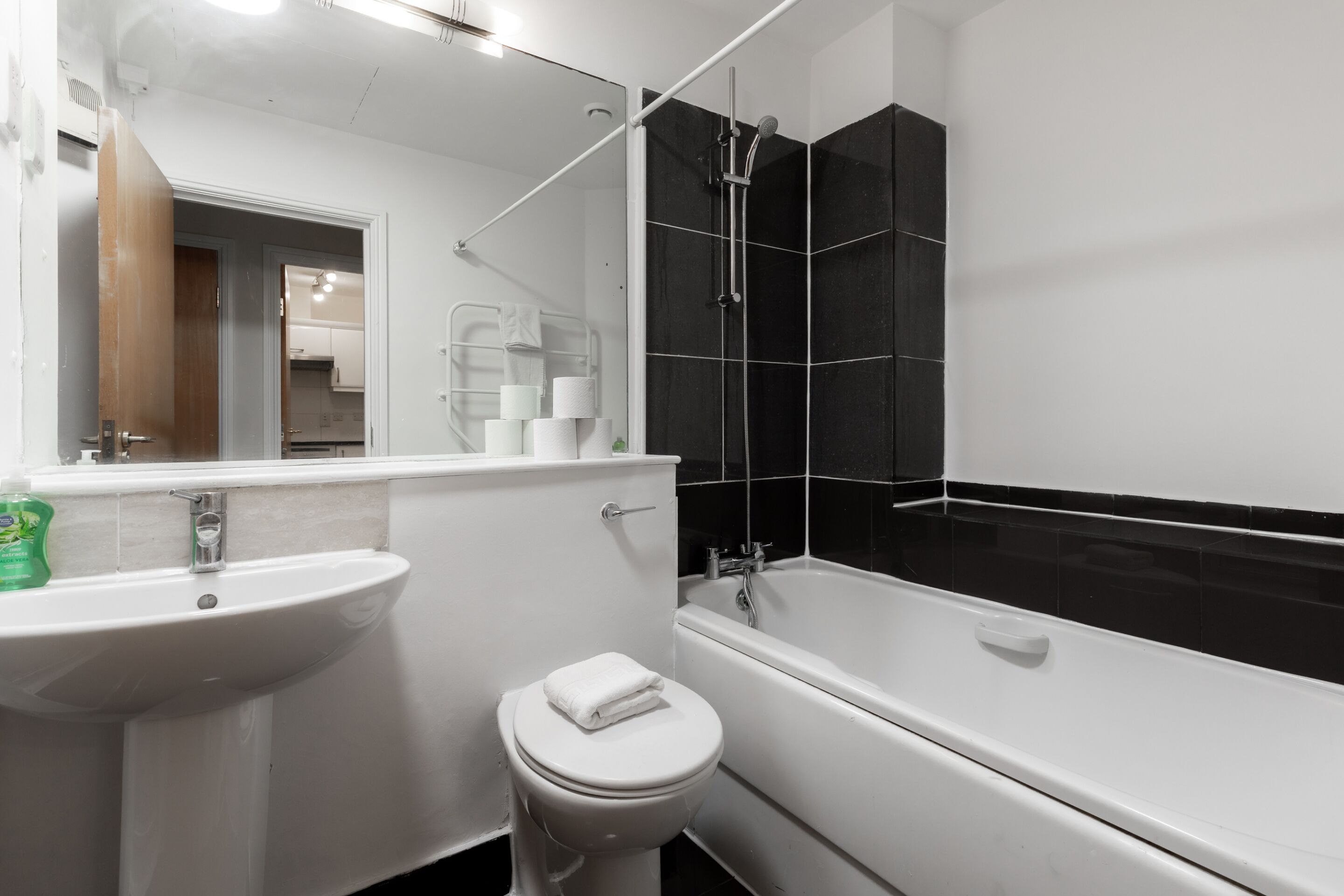 A modern bathroom with a white sink, toilet, and bathtub.