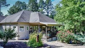 A two-story house with a covered porch and a small deck.