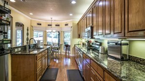 A spacious kitchen with wooden cabinets, granite countertops, and stainless steel appliances.