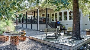 A covered outdoor area with a wooden deck, a bench, and a fire pit.