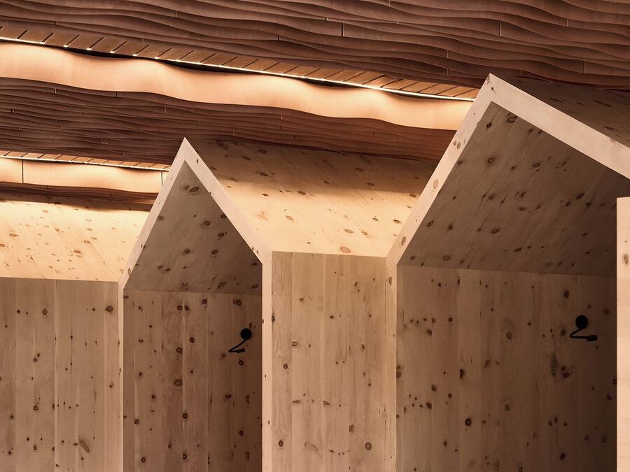 Una hilera de cabañas de madera con techo inclinado y diseño de techo ondulado.