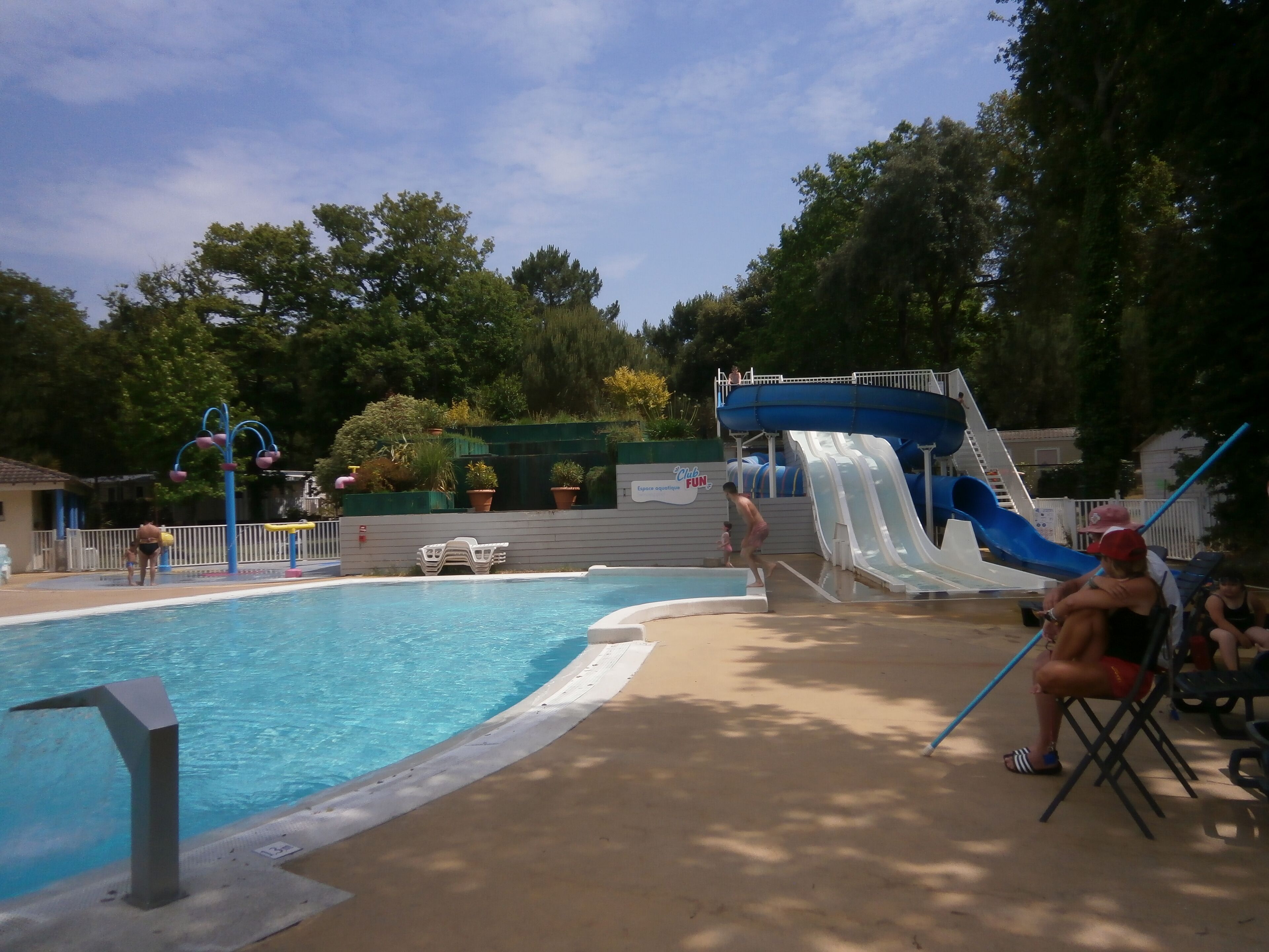 Une piscine avec un toboggan et un espace détente.