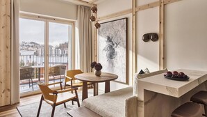 A cozy room with a round table, two chairs, a bench, a small table with a vase, and a framed picture on the wall. - Laudinella Apartments (St. Moritz)