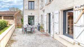 A courtyard with a table and chairs, a wooden bench, and a small garden area. - Holiday Home 'Les Echaunes' with Private Terrace, Wi-Fi and Air Conditioning (Caraman)
