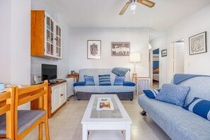 A living room with a sofa, a coffee table, a TV, and a cabinet.
