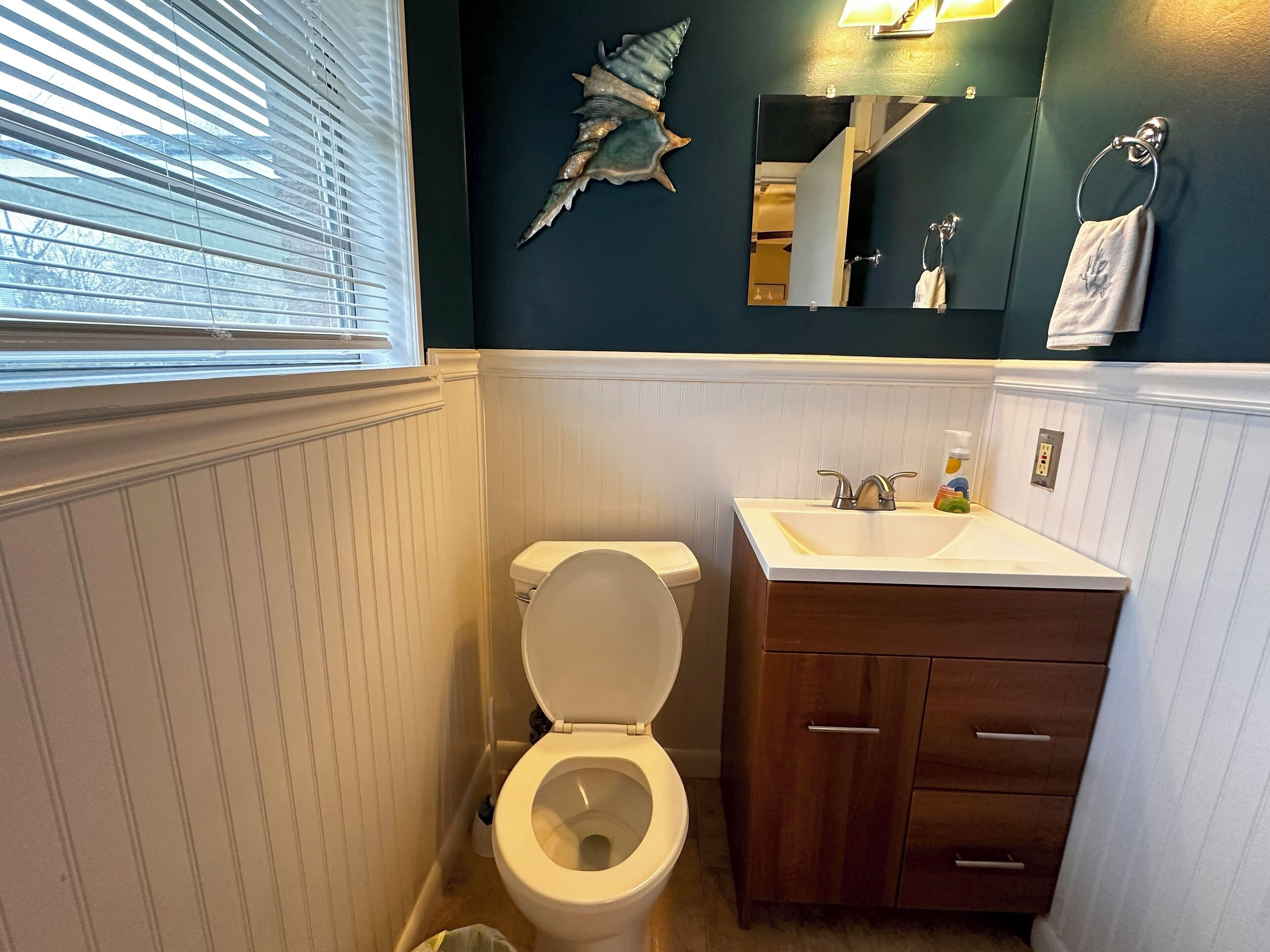 Un baño con inodoro, lavamanos y un armario de madera.