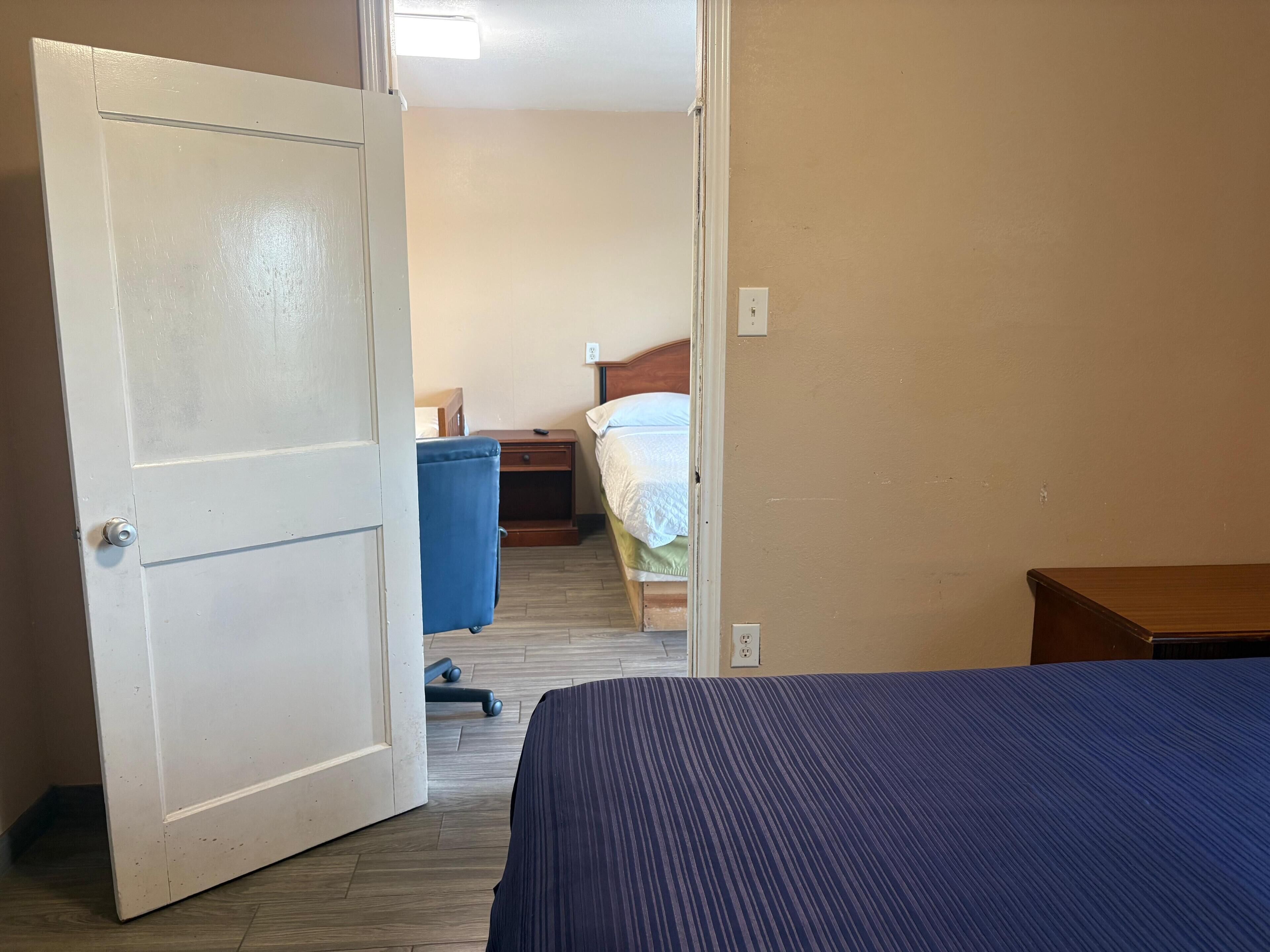 Una habitación de hotel con cama, escritorio, silla y armario.