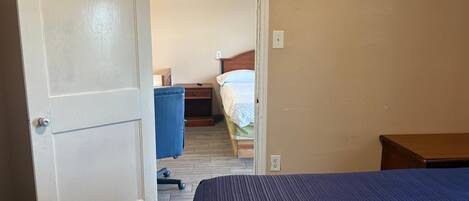 Una habitación de hotel con cama, escritorio, silla y armario.