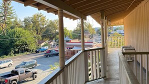 A covered balcony with a view of a parking lot and buildings in the background. - Columbia Inn Motel CA 49 (Columbia)