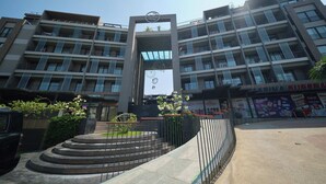 A multi-story building with a central entrance, balconies, and a commercial area on the ground floor.