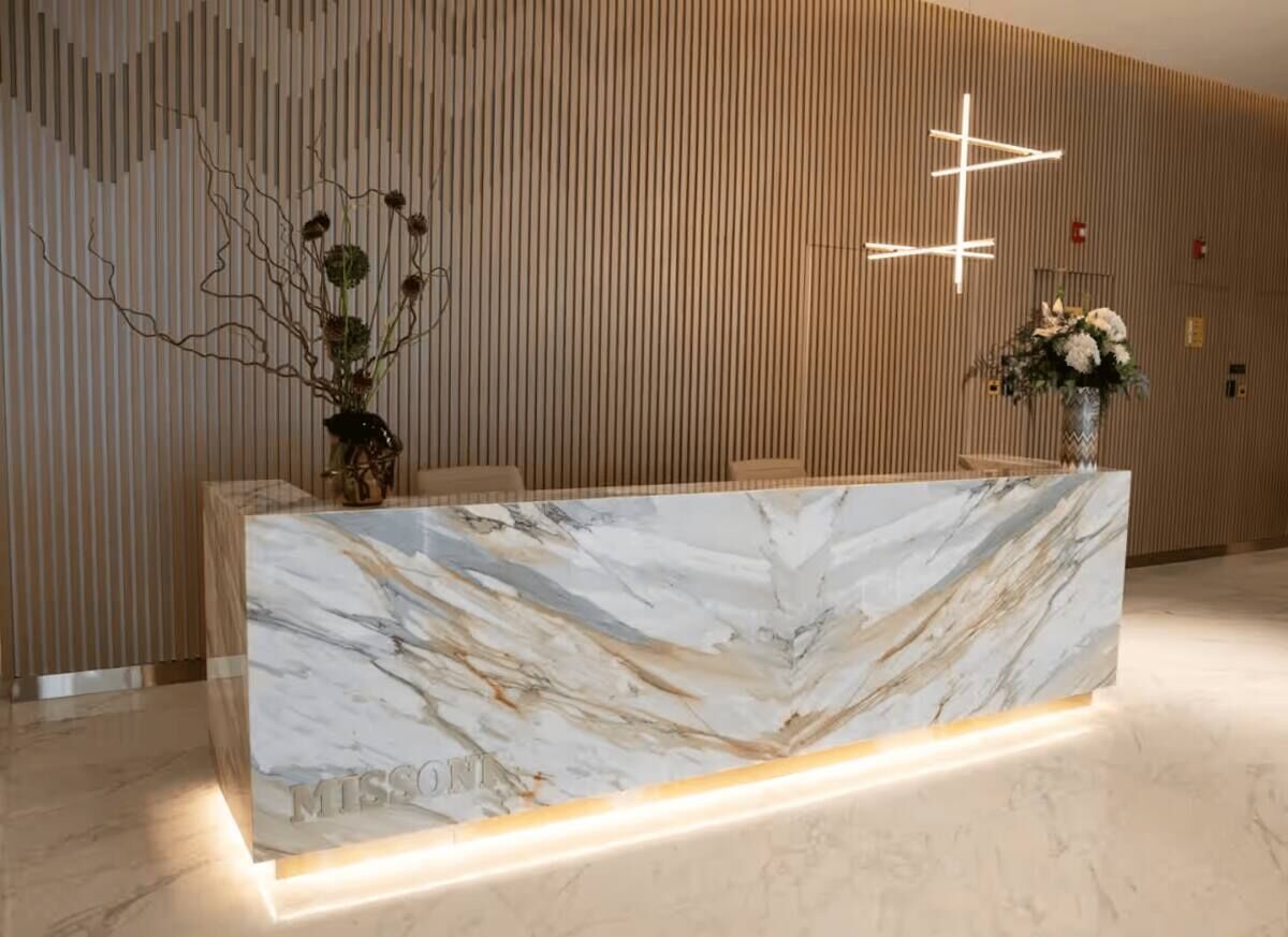 Una reception con un piano in marmo e un moderno apparecchio di illuminazione sopra.