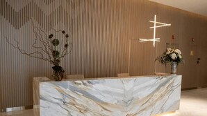 A reception desk with a marble top and a modern light fixture above it. - River Views next to Burj Khalifa (Dubai)