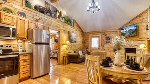 A wooden cabin interior with a kitchen, dining area, and living space. - Er80 - Can't Bear To Leave 2 Bedroom Cabin (Pigeon Forge)