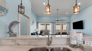 A modern kitchen with a double sink, stainless steel faucet, and pendant lighting. - Dauphin Blue - 2824 Bienville Blvd 4 Bedroom Home (Dauphin Island)