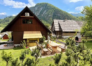 Eine Holzhütte mit geneigtem Dach, einem Schornstein und einer kleinen Veranda mit einer Bank.