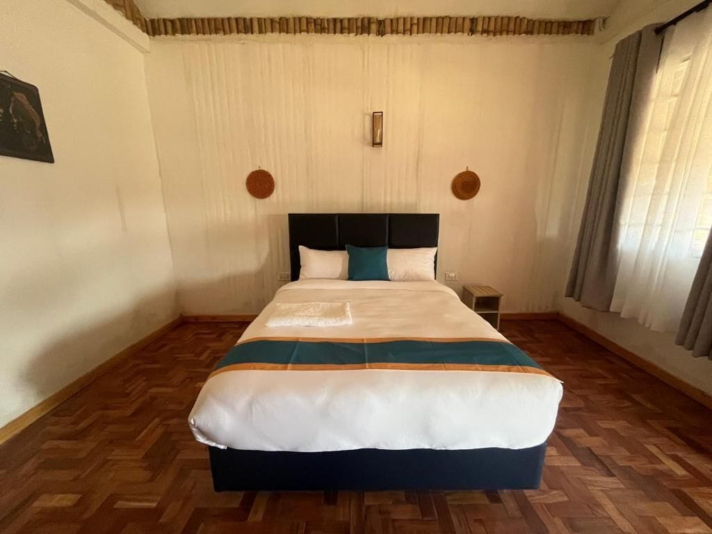 Un dormitorio con cama, mesita de noche e iluminación en la pared.