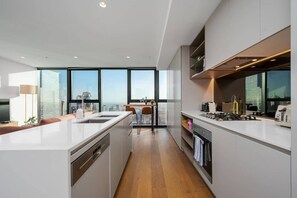 A modern kitchen with a central island, a dining area with a view, and a large window.