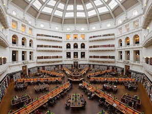 A multi-level library with a central reading area surrounded by bookshelves.