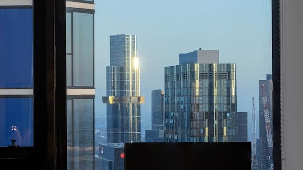 Un espacio de oficina moderno con un amplio ventanal que da a un paisaje urbano.