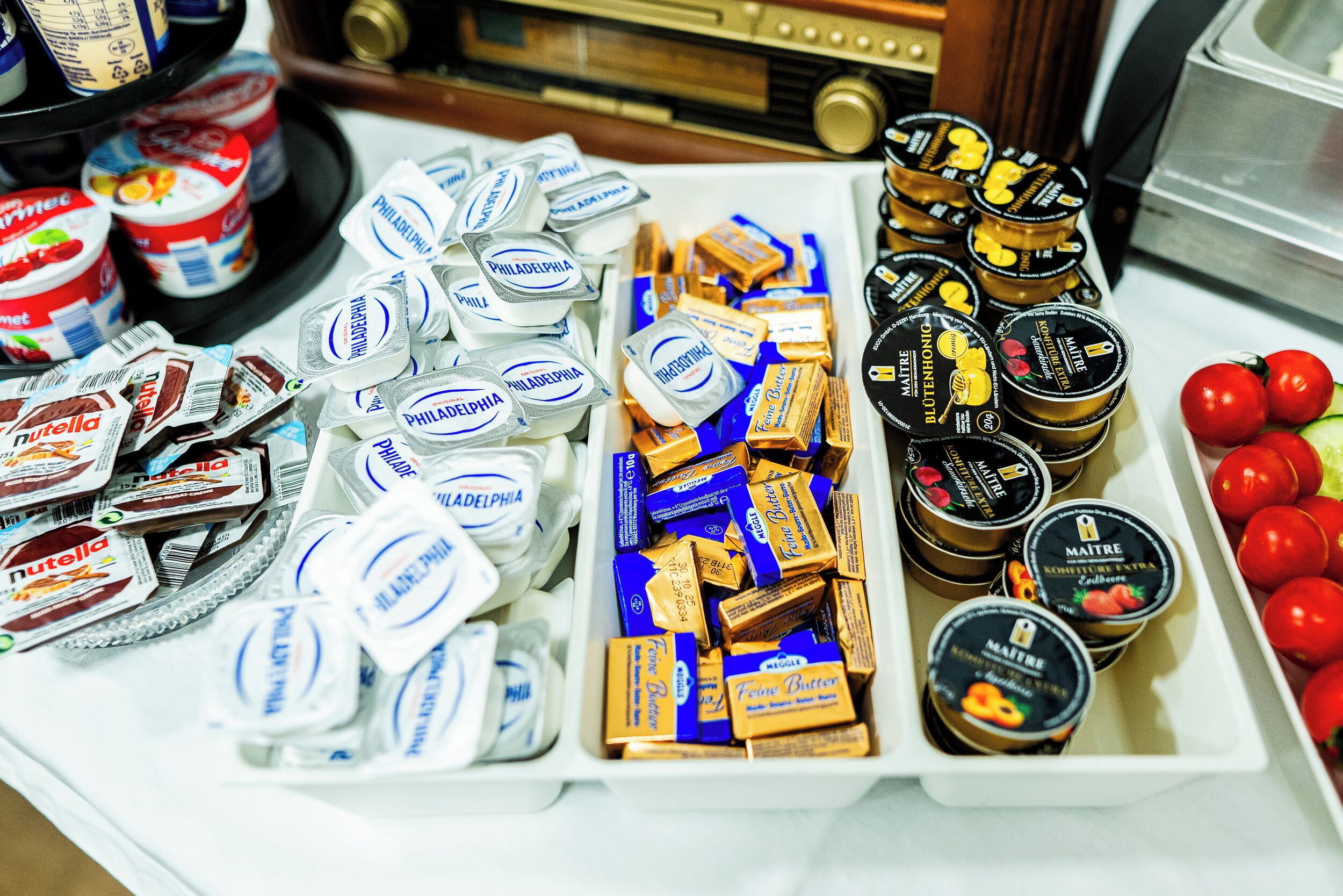 A variety of food items including jars of Nutella, Philadelphia cream cheese, and Maitreya butter.