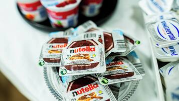 Un plateau rempli de pots de Nutella, chacun portant une étiquette indiquant un poids de 15 g.