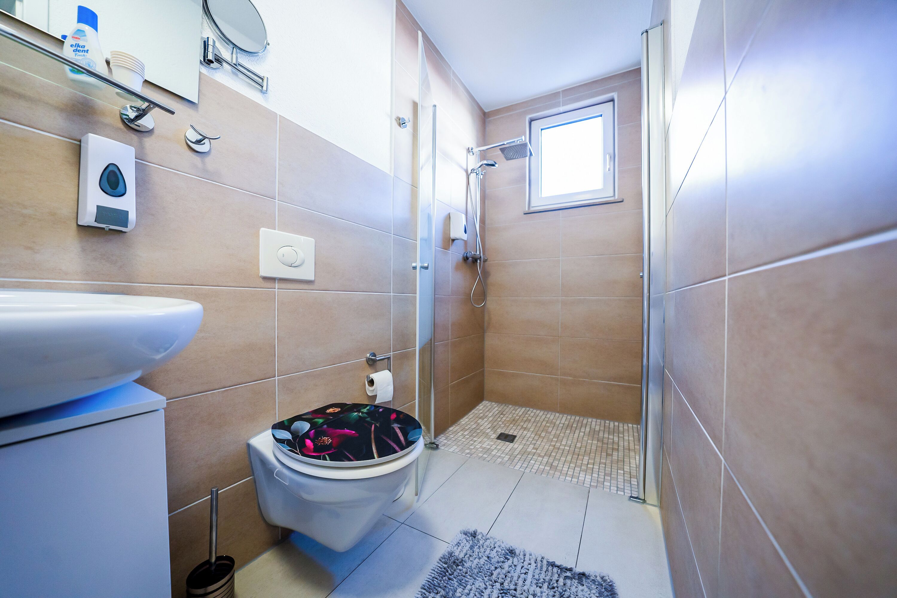 A bathroom with a toilet, bidet, and shower.