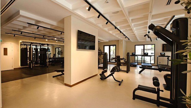 Une salle de sport équipée de divers appareils d’exercice, notamment des tapis de course et des appareils de musculation.