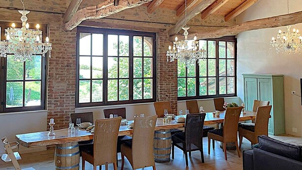 A dining area with a rustic wooden ceiling, large windows, and chandeliers. - Family-friendly oasis of well-being with a great pool - Il Roseto II (Piemonte)