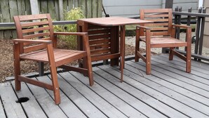 A wooden deck with a table and two chairs. - Charming 4BR Duplex Home |  5&6 (Kansas City)