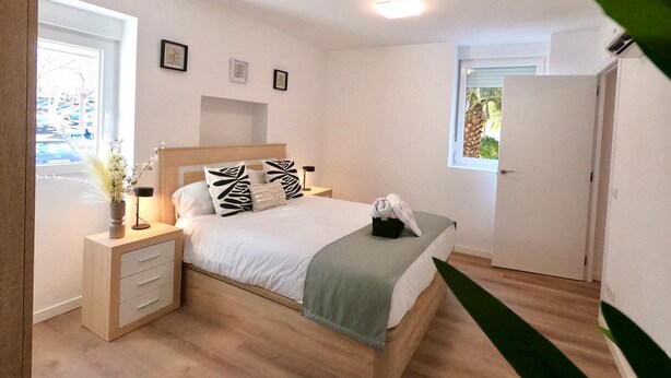 A bedroom with a wooden bed, white walls, and a small window. - Valdecanillas 1 bedroom (Madrid)