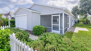 A single-story house with a garage, a covered porch, and a well-maintained lawn.