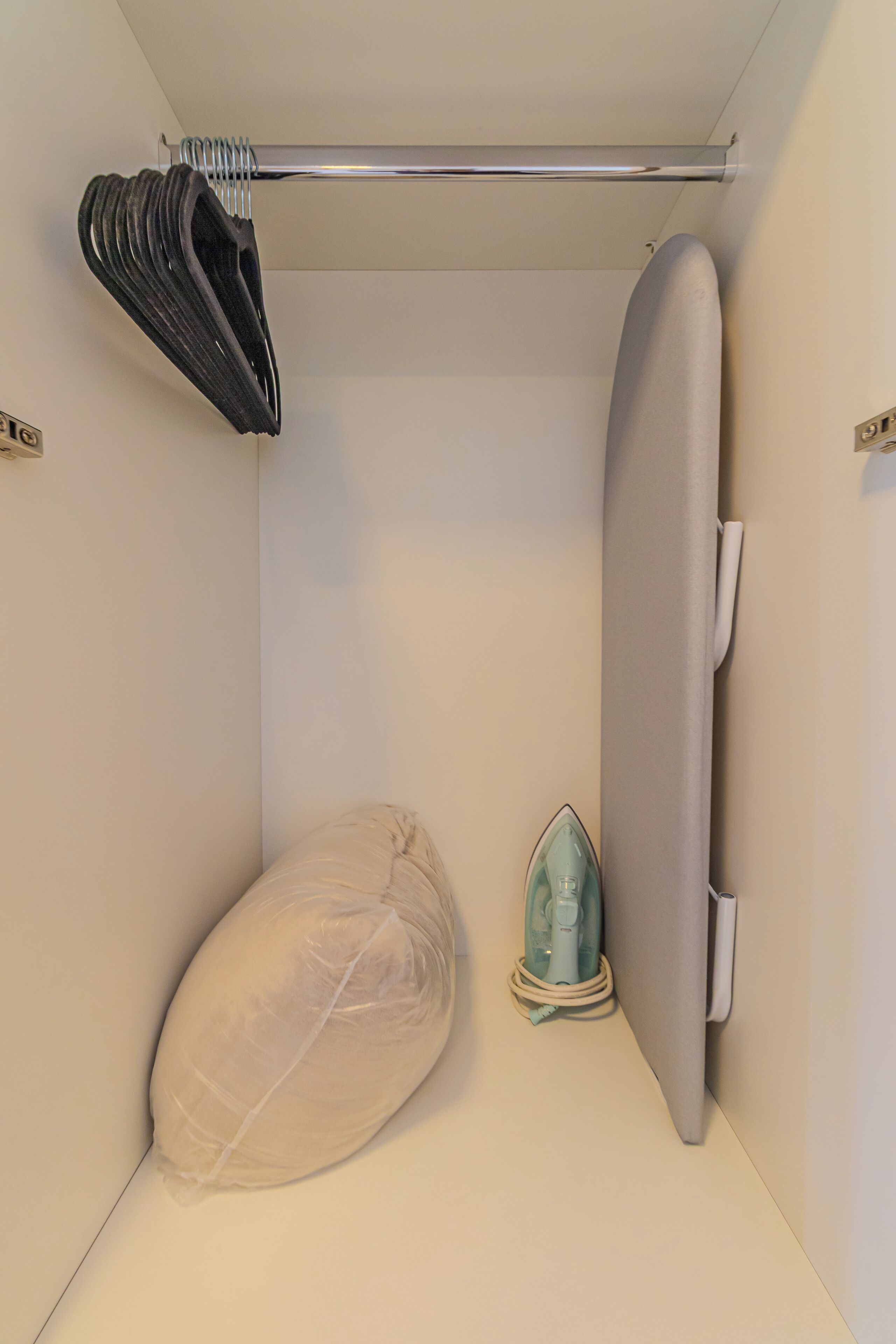 Une salle de bain compacte et bien aménagée, dotée d’une douche, d’un porte-serviettes et d’un sèche-cheveux.