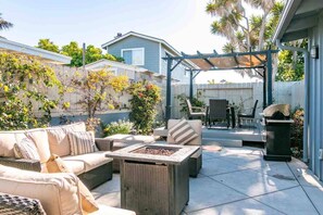 A patio area with outdoor furniture, a fire pit, and a pergola.