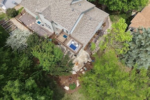 A residential property with a large house, a fenced yard, a swimming pool, and a stone patio. - Shady Grove | 4 King Beds, Dog Run & Outdoor Fun (Loveland)