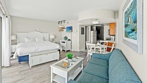 Une chambre d’hôtel moderne équipée d’un grand lit, d’un canapé, d’un bureau et d’un coin repas.