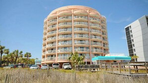 Un hôtel à plusieurs étages, doté d’une façade circulaire, de balcons et d’un espace extérieur couvert.