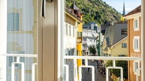 Une vue de rue avec des bâtiments, le clocher d’une église et une montagne en arrière-plan.