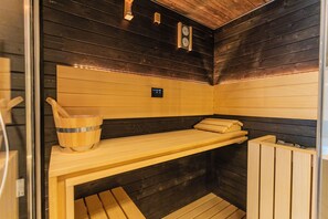 A sauna with wooden benches, a wooden bucket, and a control panel. - VBM SUITE & SPA APARTMENTS (Bari)