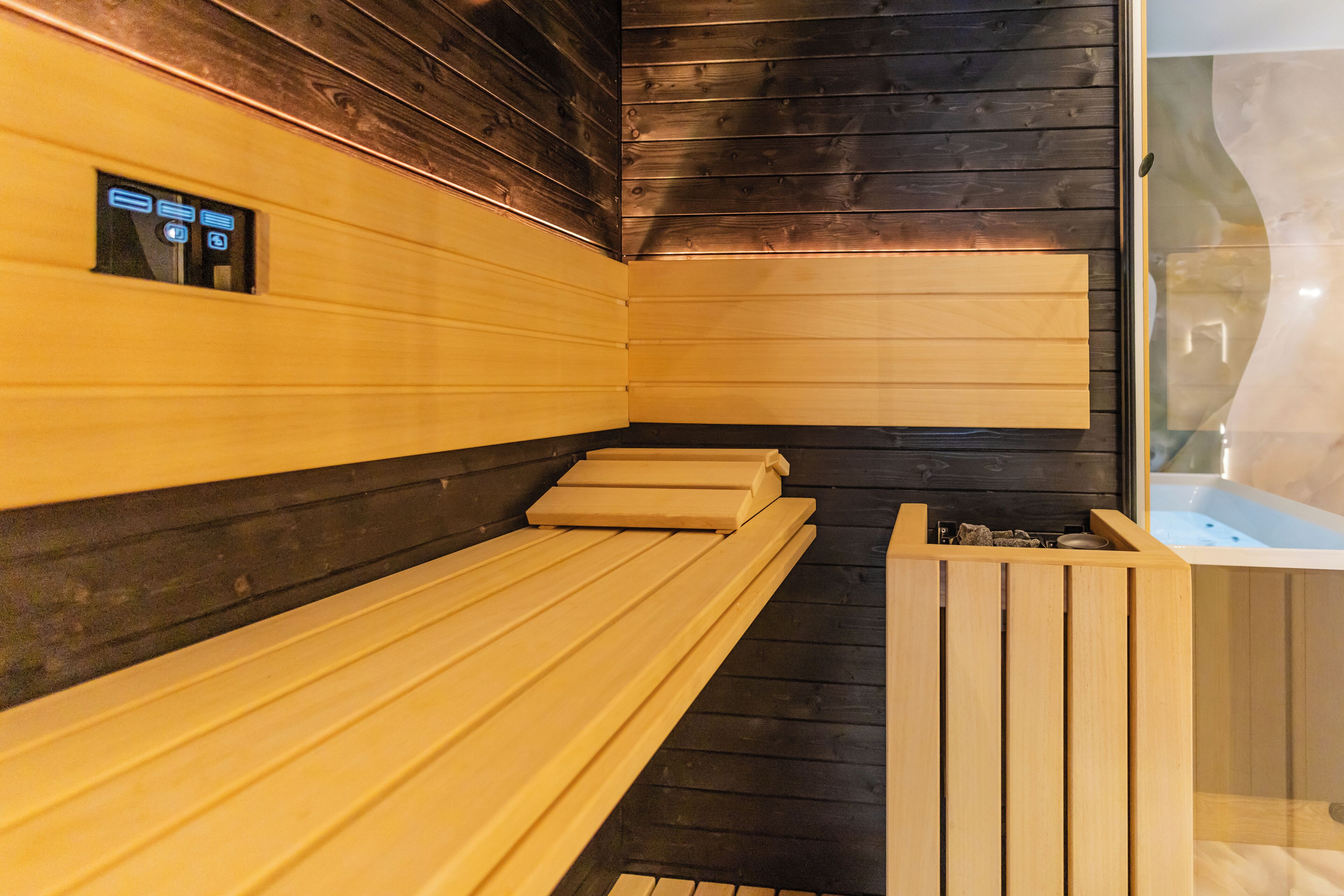 Un sauna avec des bancs en bois et un panneau de commande.
